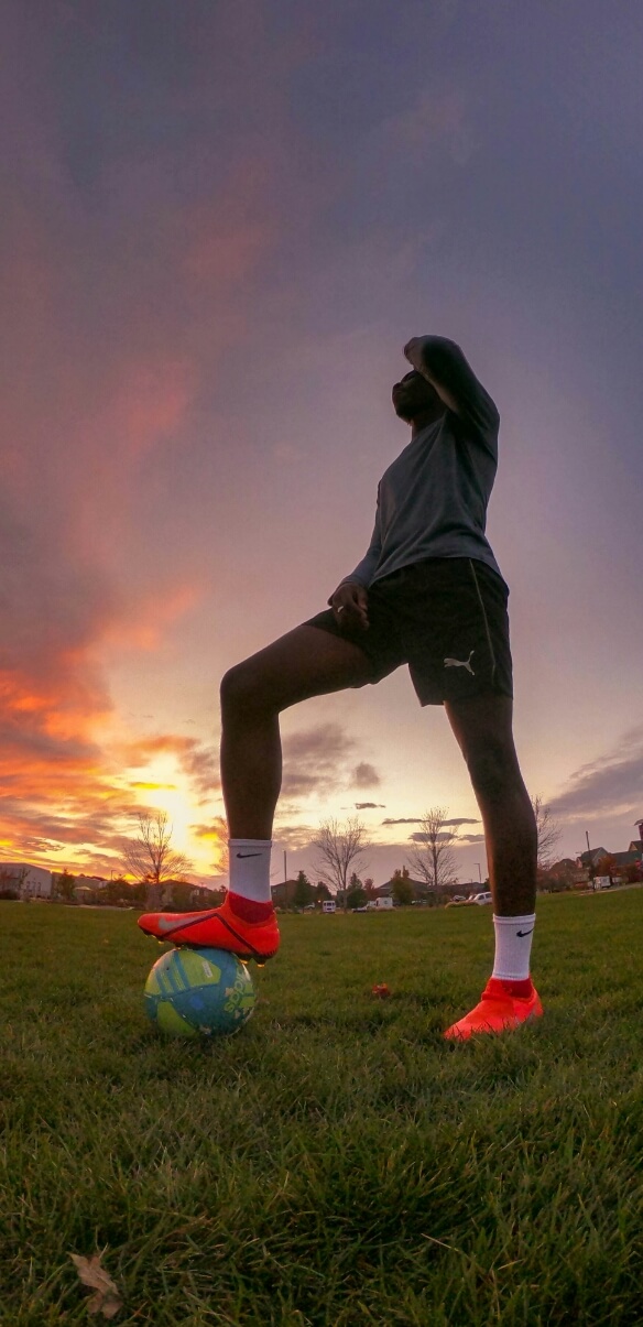 Players warming up on a floodlit football pitch